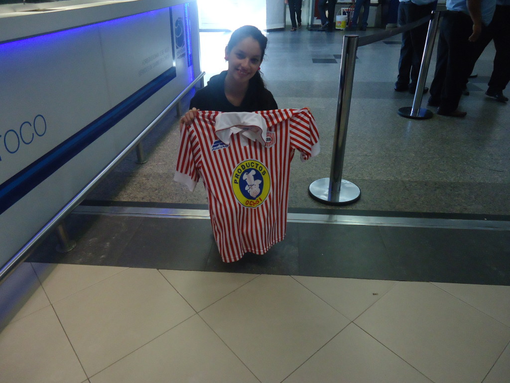 Aqui la joven becaria portando la bandera del Rayadito en el aeropuerto de Miami