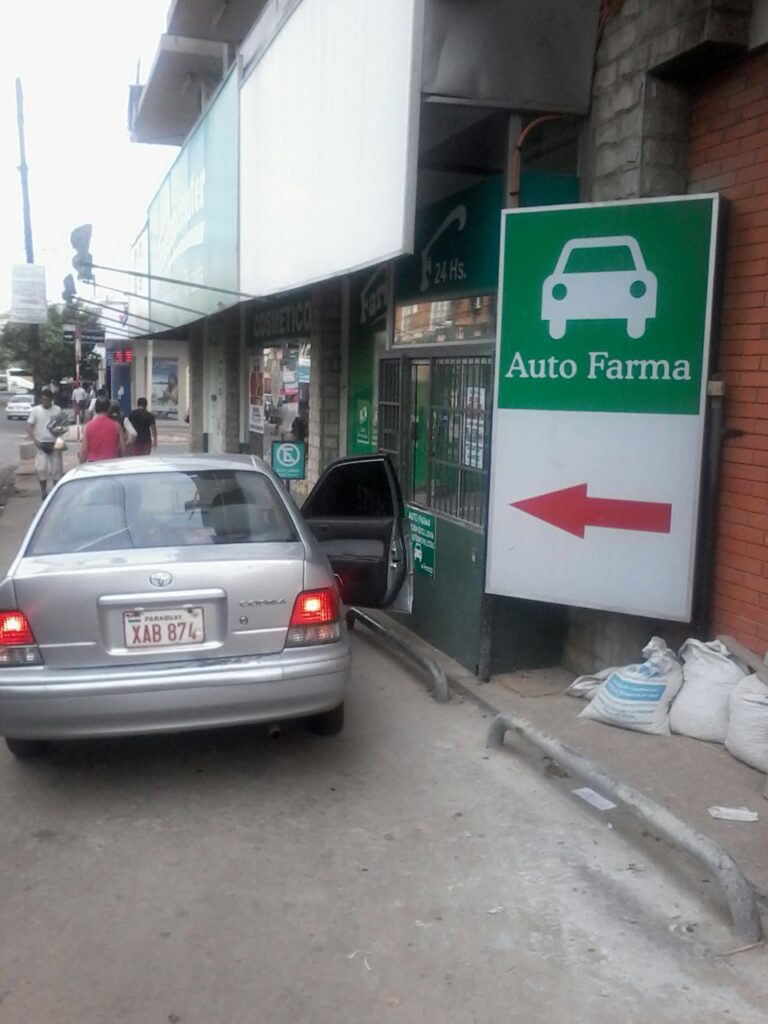 El paso para los peatones esta practicamente "cerrado" debido a los vehículos que entran a comparar en la farmacia