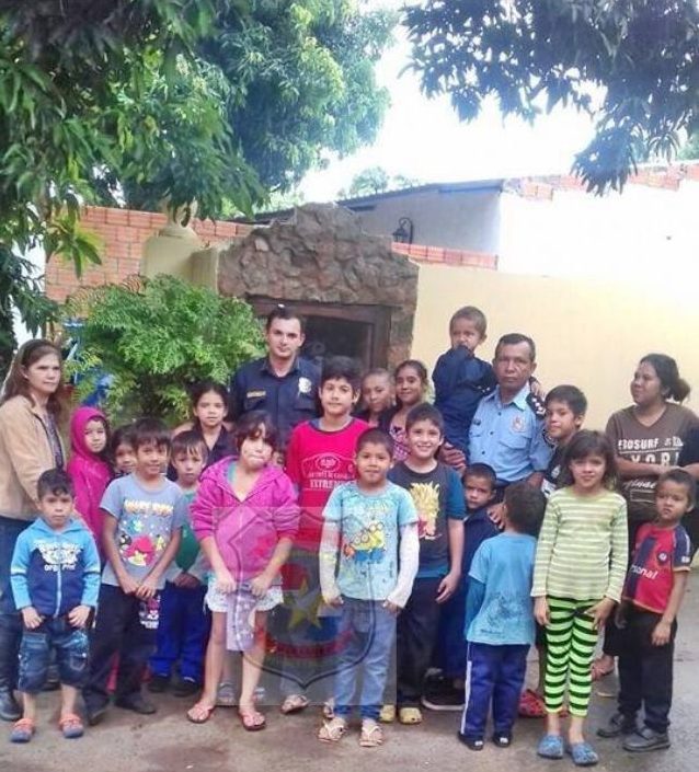 El comisario (uniforme celeste) con un grupo de los niños